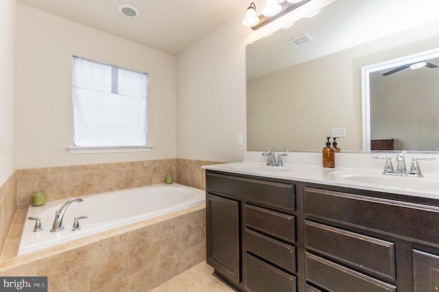 bathroom with vanity, a relaxing tiled tub, and tile patterned floors