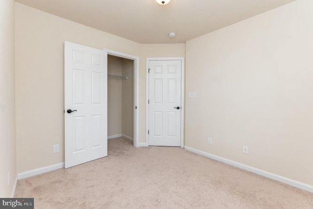 unfurnished bedroom featuring light colored carpet and a closet