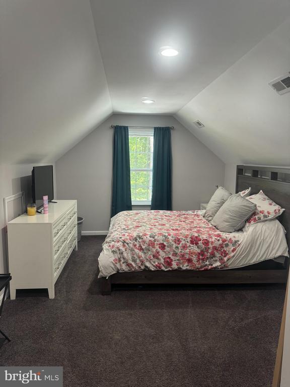 carpeted bedroom with lofted ceiling