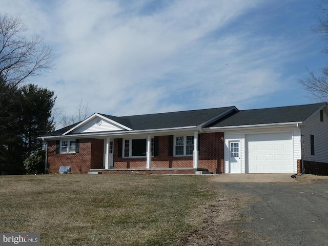 ranch-style home with a garage, aphalt driveway, a front lawn, and brick siding