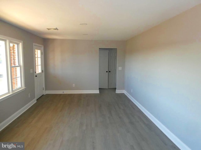 empty room with visible vents, baseboards, and wood finished floors