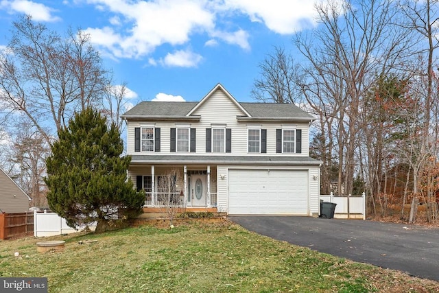 view of front facade featuring covered porch, driveway, an attached garage, and fence