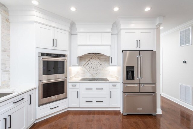 kitchen featuring light stone countertops, stainless steel appliances, and white cabinets