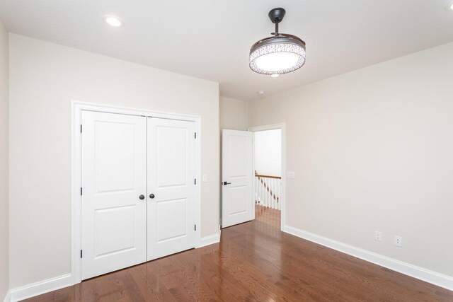 unfurnished bedroom featuring a closet and dark hardwood / wood-style floors