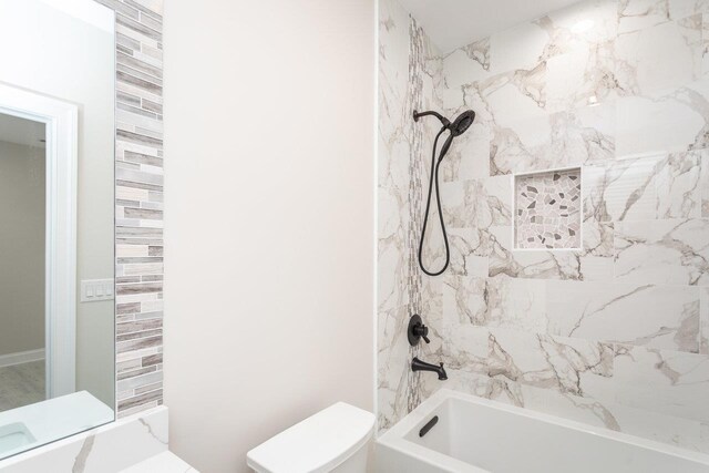 bathroom featuring tiled shower / bath and toilet