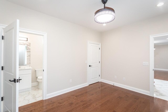 unfurnished bedroom with dark hardwood / wood-style floors and ensuite bathroom