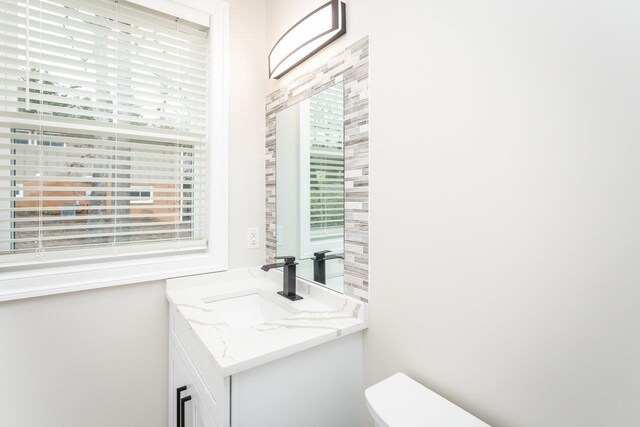 bathroom featuring vanity, plenty of natural light, and toilet