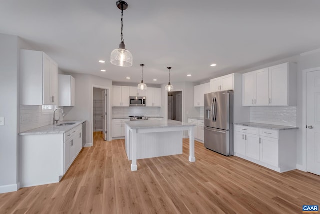 kitchen featuring stainless steel appliances, a kitchen island, and white cabinets