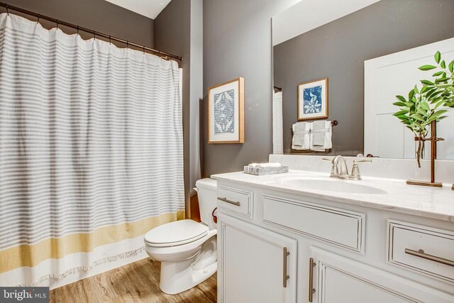 bathroom featuring vanity, hardwood / wood-style floors, and toilet