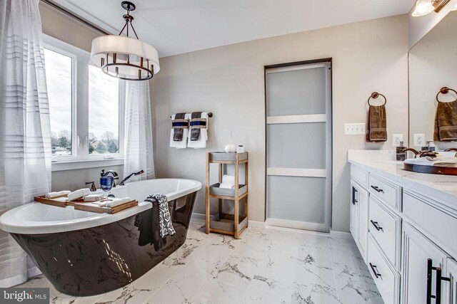 bathroom featuring a notable chandelier, vanity, and a tub