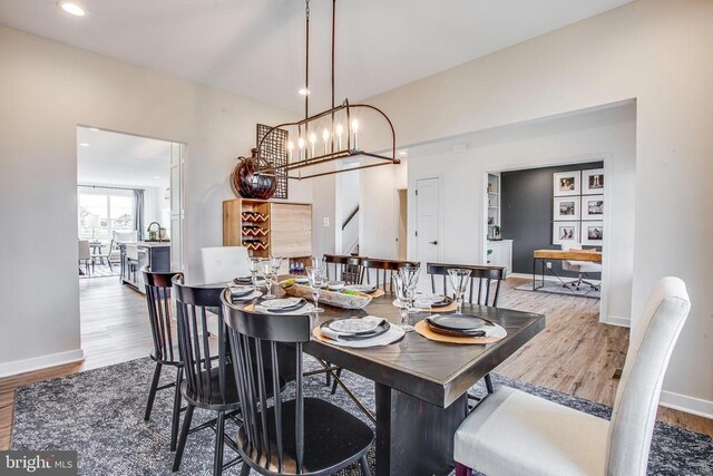 dining space featuring a chandelier, sink, and light wood-type flooring