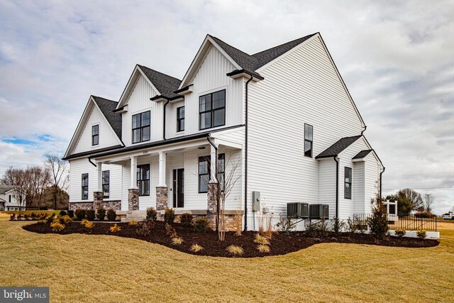 view of front of home featuring a front yard, covered porch, and central air condition unit