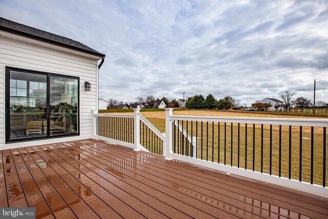 wooden deck featuring a lawn