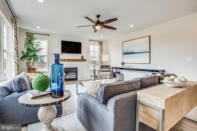 living room featuring a wealth of natural light, ceiling fan, and light wood-type flooring