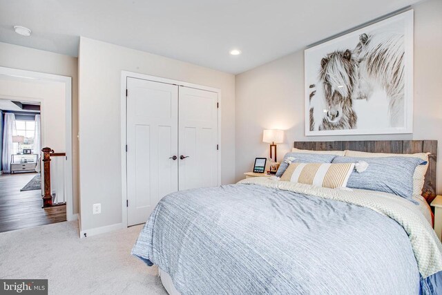 bedroom with light colored carpet and a closet