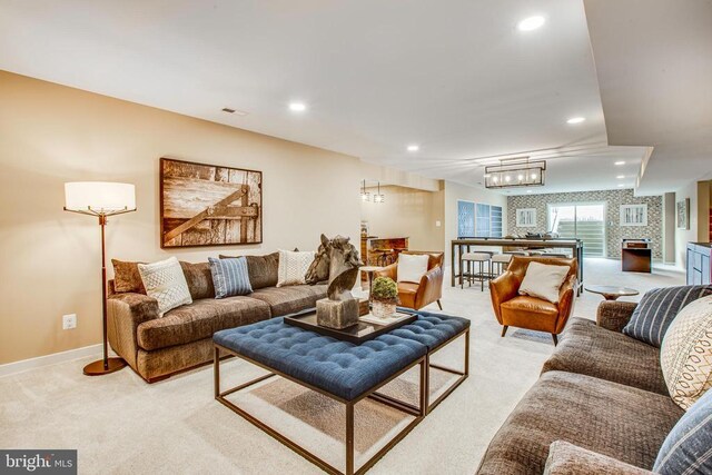 carpeted living room featuring a notable chandelier