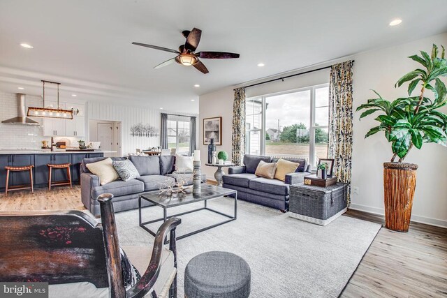 living room featuring light hardwood / wood-style flooring and ceiling fan