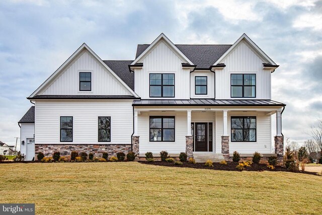 modern farmhouse featuring covered porch and a front yard