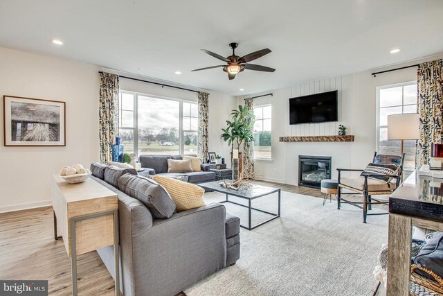 living room featuring light hardwood / wood-style floors and ceiling fan