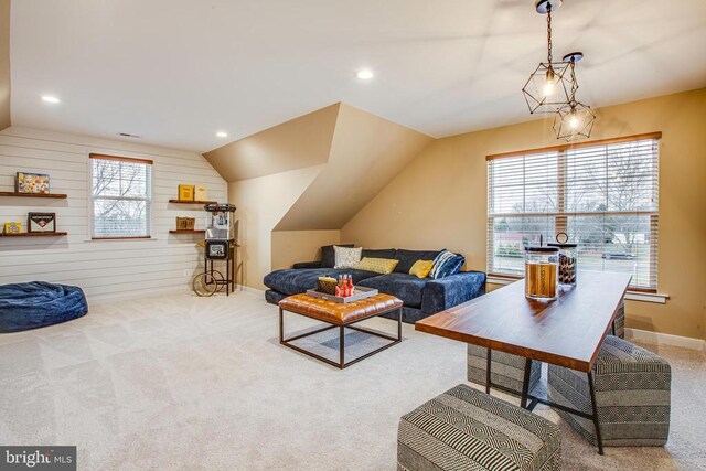 living room with light colored carpet, wooden walls, and vaulted ceiling