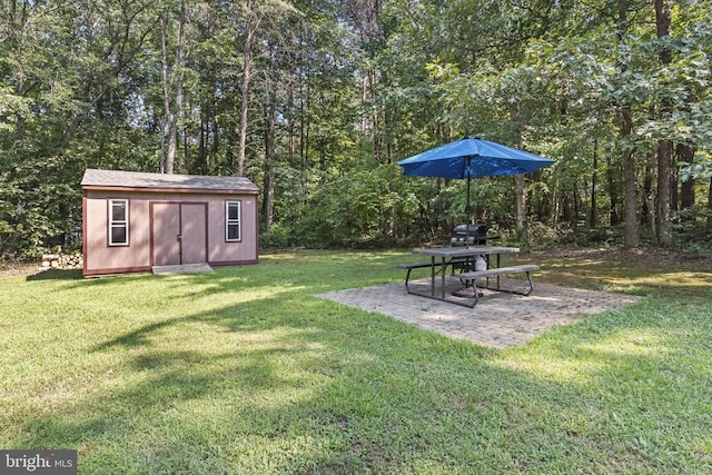 view of yard featuring an outdoor structure, a view of trees, a shed, and a patio