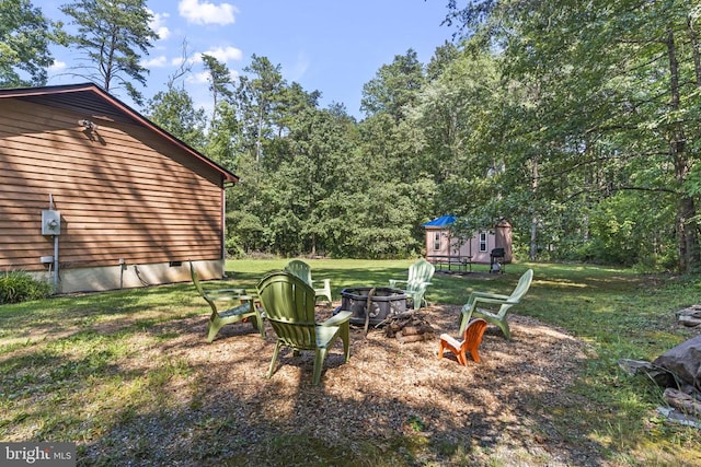 view of yard featuring an outdoor structure and an outdoor fire pit