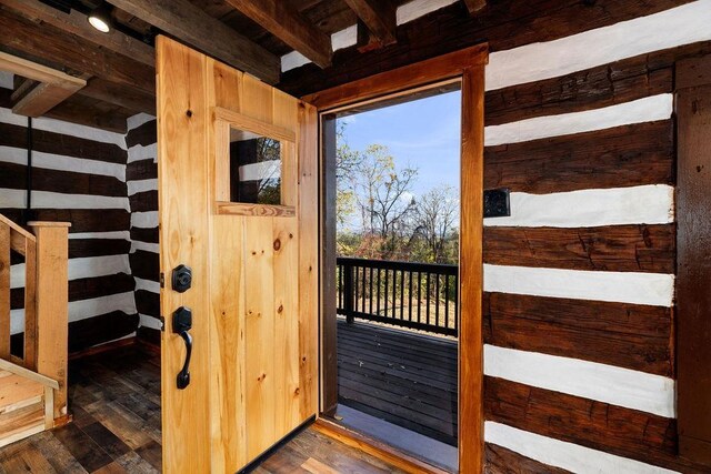 doorway with dark hardwood / wood-style flooring and wooden walls