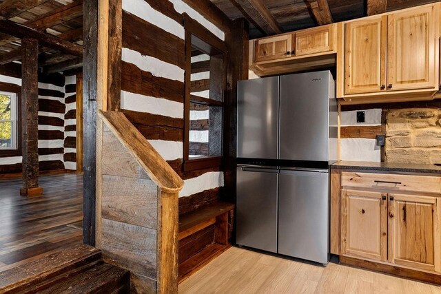 kitchen with backsplash, stainless steel fridge, light hardwood / wood-style floors, and light brown cabinets