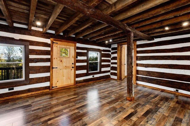 interior space with wooden walls, dark hardwood / wood-style floors, beam ceiling, and wooden ceiling