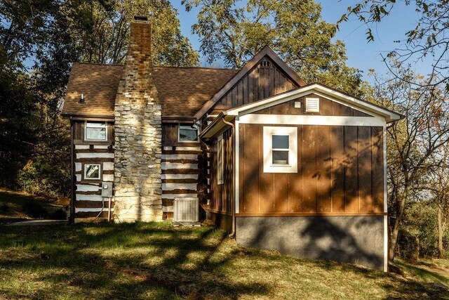 exterior space with central AC unit and a yard