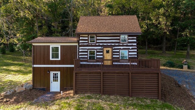 exterior space featuring a wooden deck and a front yard