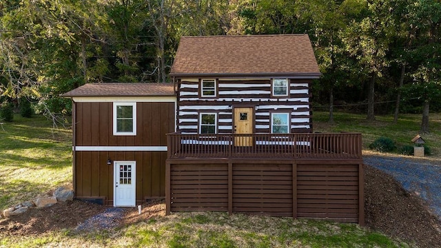 exterior space featuring a wooden deck and a front yard