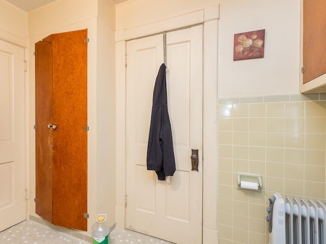 bathroom with tile walls and radiator heating unit