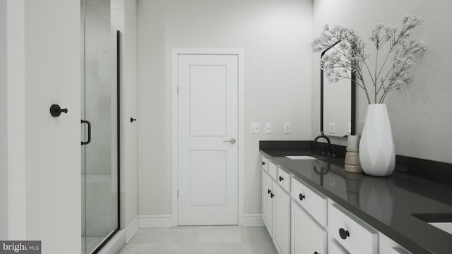 bathroom with baseboards, double vanity, a sink, and a shower stall