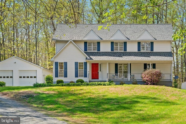 traditional home with a shingled roof, an outbuilding, a porch, a front yard, and a garage