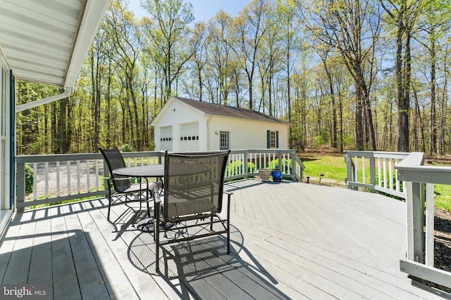wooden deck with an outdoor structure and a detached garage