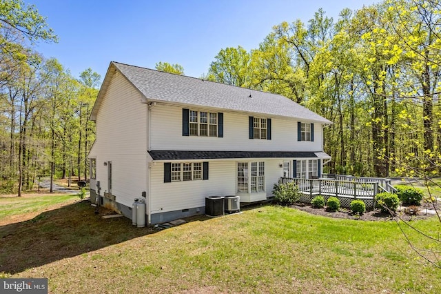 back of property with central AC, a wooden deck, and a lawn
