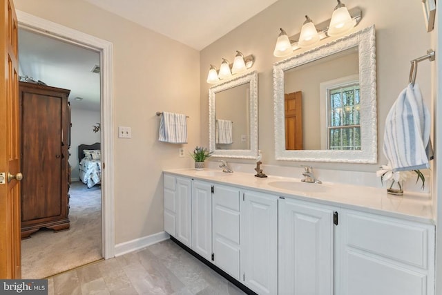 bathroom featuring baseboards, a sink, and double vanity