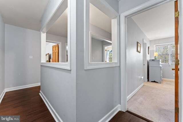 hallway featuring baseboards and wood finished floors