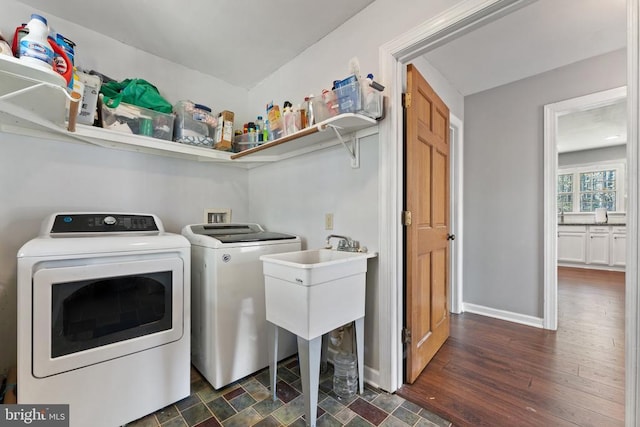 clothes washing area with dark wood-style floors, washer and clothes dryer, a sink, baseboards, and laundry area