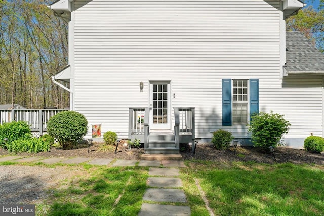back of house with a shingled roof