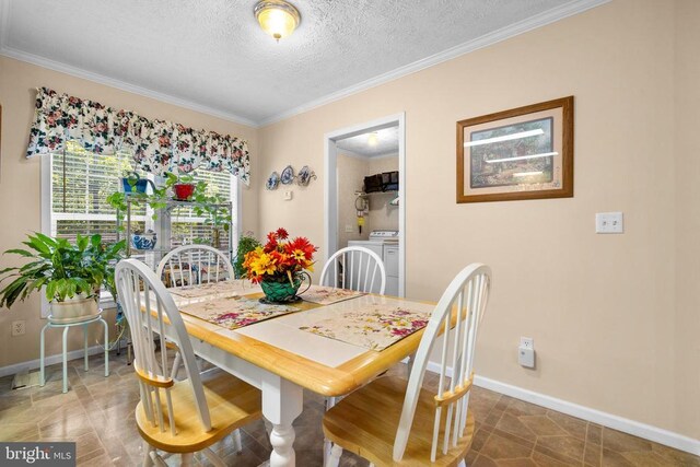 dining space featuring crown molding, washing machine and dryer, and a textured ceiling