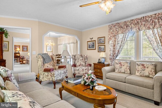 carpeted living room featuring ornamental molding, a textured ceiling, and a notable chandelier