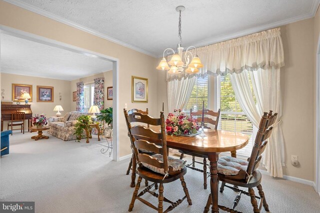 dining room featuring a notable chandelier, ornamental molding, a textured ceiling, and carpet