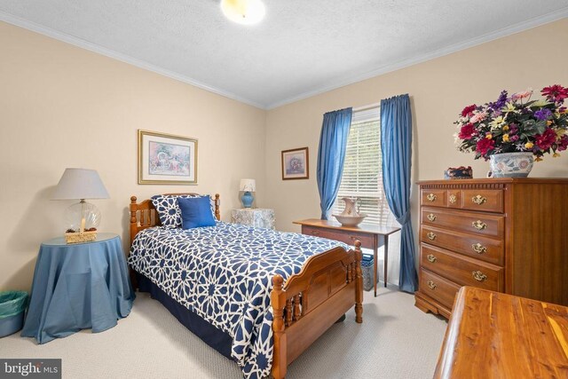 bedroom with ornamental molding and light colored carpet