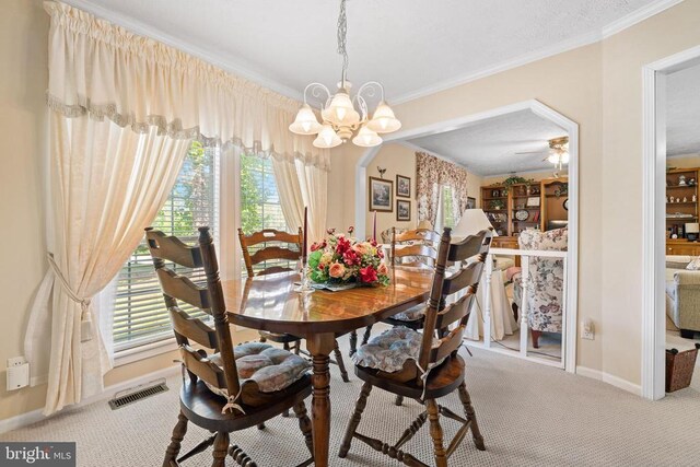 dining area with crown molding, a healthy amount of sunlight, and carpet flooring