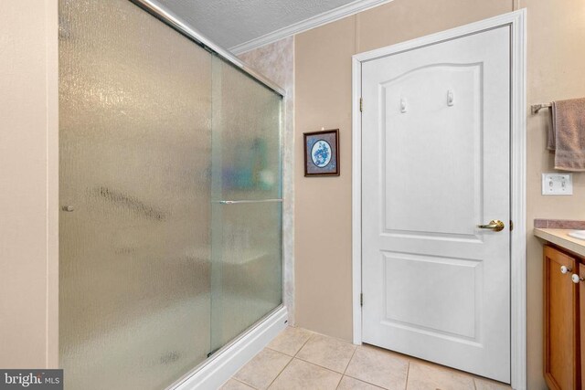 bathroom with tile patterned flooring, vanity, walk in shower, crown molding, and a textured ceiling