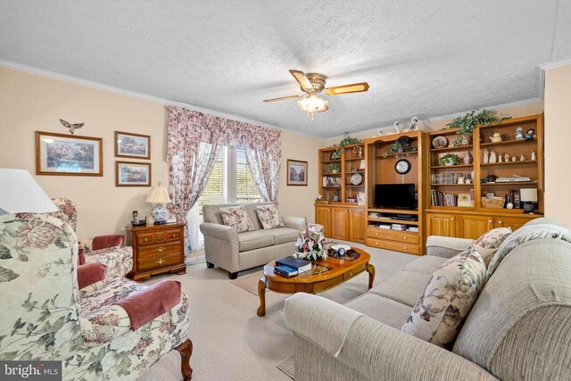 living room featuring ceiling fan, crown molding, light colored carpet, and a textured ceiling