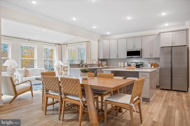 kitchen with gray cabinetry, tasteful backsplash, a center island, and appliances with stainless steel finishes