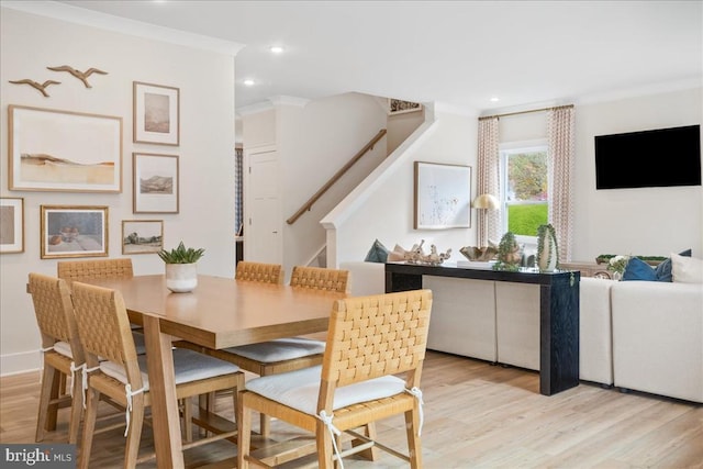 dining room featuring crown molding and light hardwood / wood-style flooring